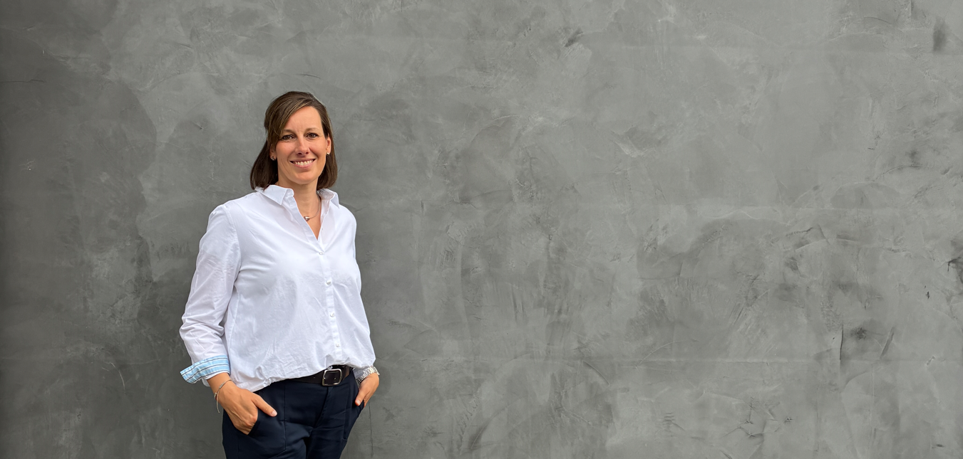 Sandra Pape vor einer grauen Wand.